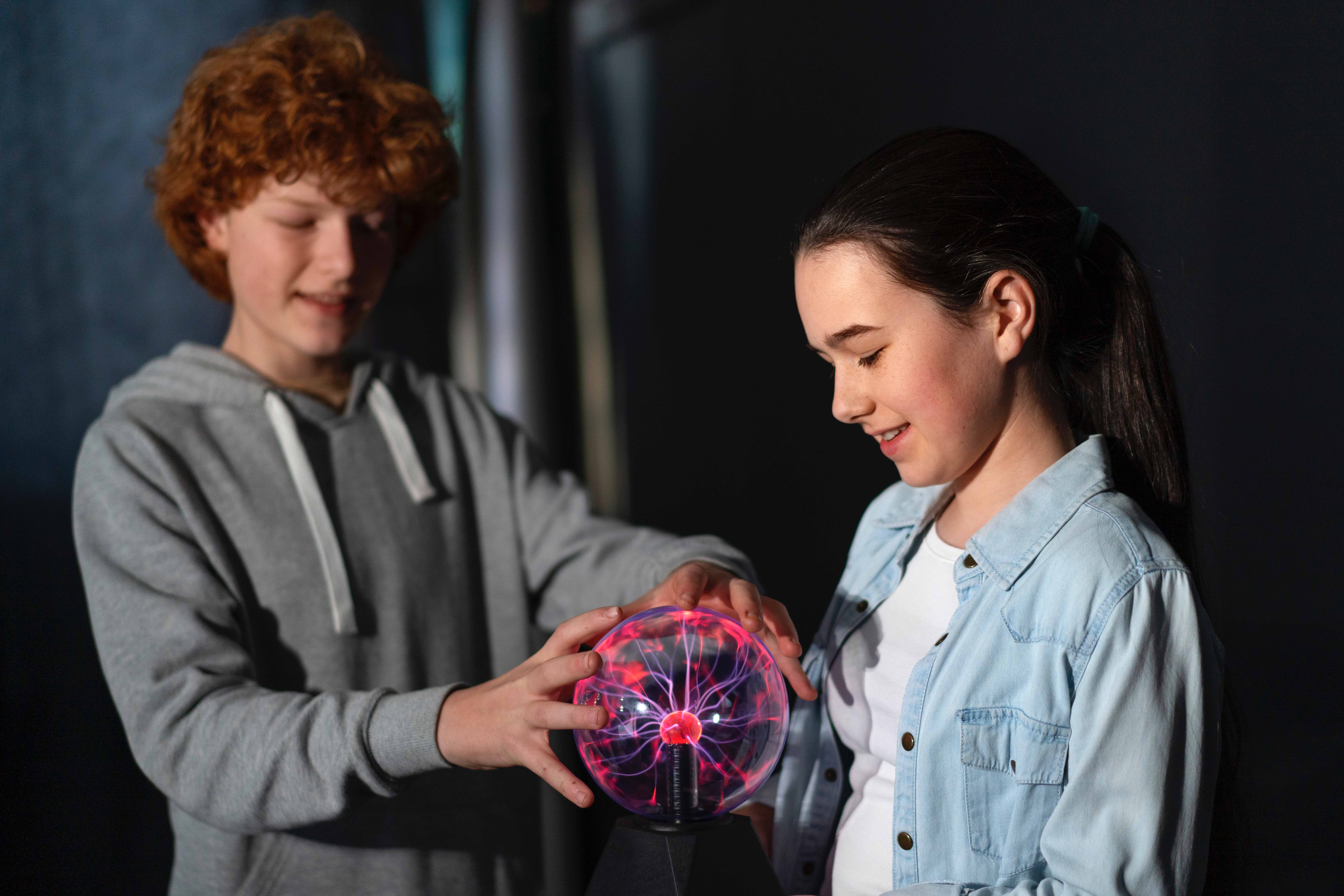Young students exploring science through hands-on interaction with a plasma ball